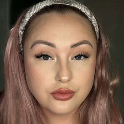 Close-up of a person with pink hair and a decorative headband against a dark background. Model wears Megavolume Fastbond Press-on Cluster Lashes Closeup - Youthphoria Australia