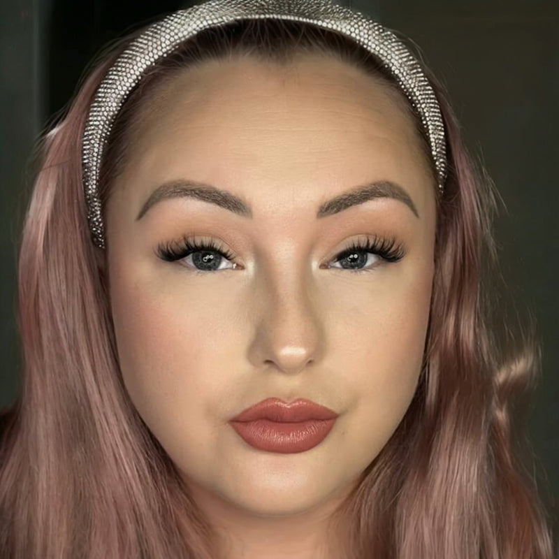 Close-up of a person with pink hair and a decorative headband against a dark background. Model wears Megavolume Fastbond Press-on Cluster Lashes Closeup - Youthphoria Australia