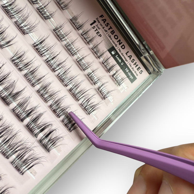 Eyelash extension kit with false eyelashes and tweezers on a white background