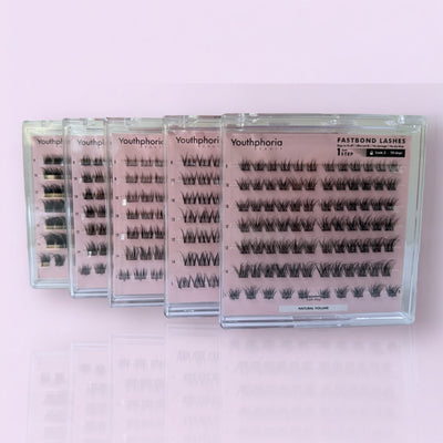 Multiple boxes of Youthphoria false eyelashes on a pink background